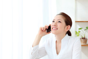 スマホを片手に電話をする女性