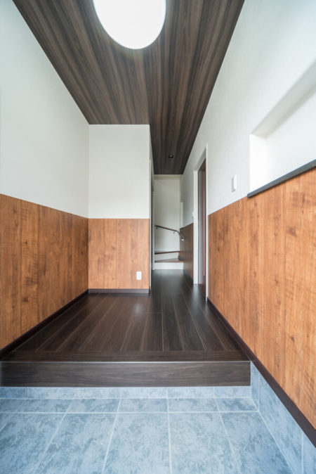 玄関ホールの床材は、国産材の植林木を使用した環境配慮型のフローリング、アイカのタフユカ「グレイスバーチ」色。